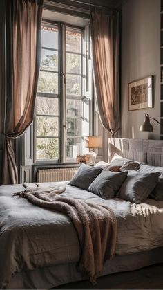 Cozy bedroom with a large window, sheer curtains, a neatly made bed with cushions and a throw, soft natural light streaming in. Soft Cozy Bedroom, Cozy Super Soft Winter Robe, Cozy Warm Bedroom, Cozy Winter Robe Super Soft, Cozy Rainy Day Aesthetic Bedroom, Cozy Bedroom Rain, Cozy Bed Rain, Self Care Space, Bedroom Decor Cozy