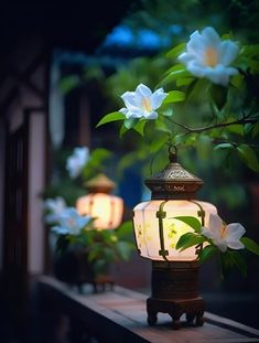 a lantern is lit up with flowers in the background