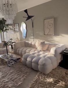 a living room filled with white furniture and lots of pillows on top of carpeted flooring