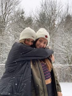 two women hugging each other in the snow