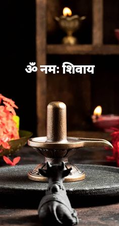 a small metal device sitting on top of a wooden table next to flowers and candles