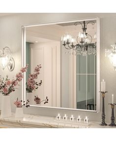 a large mirror sitting on top of a counter next to a vase filled with flowers