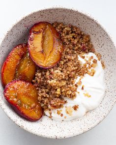 a bowl filled with granola, peaches and yogurt