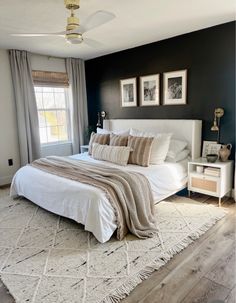 a bedroom with black walls and white bedding