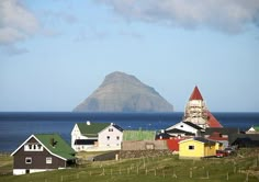 the small village has many colorful houses on it's sides and there is a mountain in the background