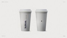 two coffee cups sitting next to each other on top of a white surface with the words kokoba printed on them