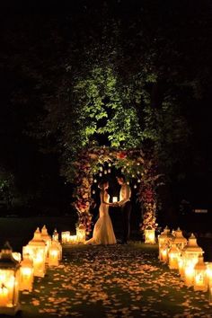 a bride and groom standing in front of lit candles