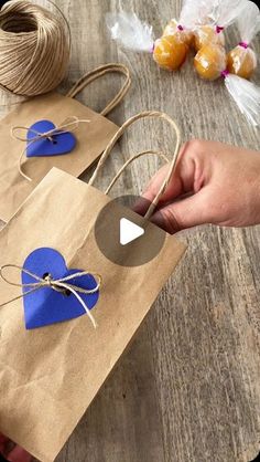 a person holding a brown paper bag with blue hearts on it and twine spools