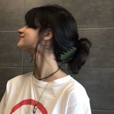 a woman with black hair wearing a white shirt