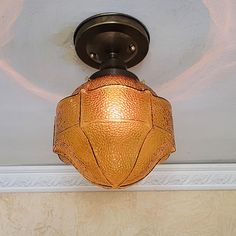 a light fixture mounted on the ceiling in a room with beige walls and white trim