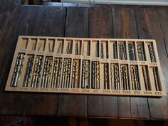 a wooden box filled with lots of different types of screwdrivers on top of a table