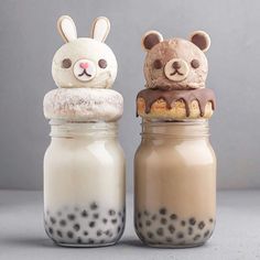 two jars filled with food and one has an animal head on it's top