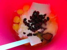 a bowl filled with fruit and yogurt on top of a pink table