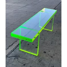 a neon green table sitting on the side of a road next to a parking lot