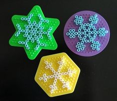 three different colored plastic objects on a black surface, one with white and blue dots