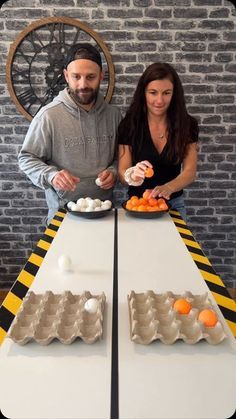 a man and woman standing at a table with plates of food in front of them