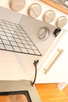 a stove top oven sitting inside of a kitchen next to a counter with knobs on it