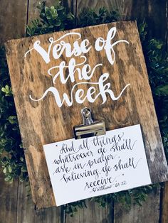 the verse of the week is written on a clipboard next to a green wreath