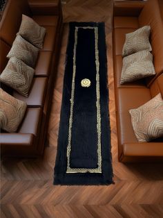 an overhead view of a living room with brown couches and black rug on the floor