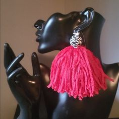 a pair of black mannequins with pink tasselled earrings on them