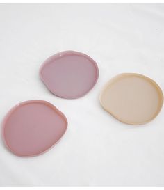 three oval plates sitting on top of a white table