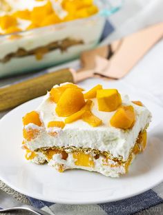 a piece of cake on a white plate with fruit toppings and silverware next to it