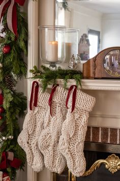 christmas stockings hanging from a mantle with candles