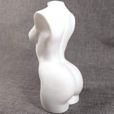 a small white sculpture sitting on top of a gray cloth