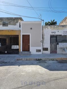 an empty street in front of two buildings with graffiti on the walls and door frames