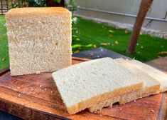 two slices of white bread sitting on top of a wooden cutting board