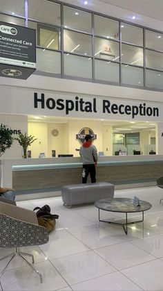 a man standing in front of a hospital reception counter with people sitting at the desk