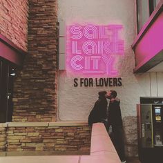 two people kissing in front of a sign that says salt lake city s for lovers