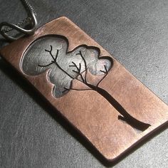 a metal pendant with two leaves on it