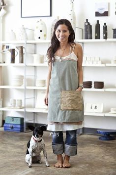 a woman standing next to a small dog