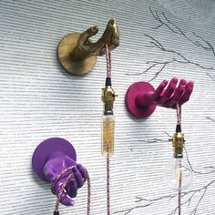 purple objects are hanging on the wall next to a light bulb and plugged in wires