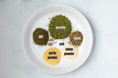 spices on a white plate labeled in the different types of powders and seasonings