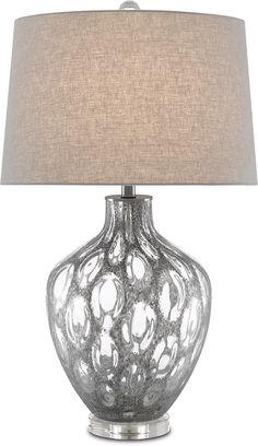 a glass table lamp with a beige shade