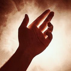 a person's hand reaching up into the air