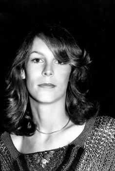 a black and white photo of a woman with shoulder length wavy hair wearing a sweater