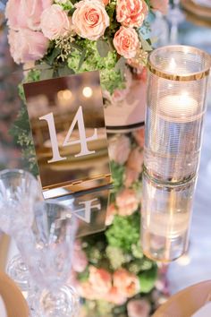 the table is set with flowers, candles and place cards for guests to sit at