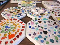 several pieces of art made out of different colored glass and marbles on a table