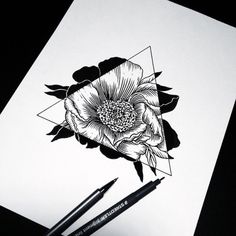 a black and white drawing of a flower on paper with two markers next to it