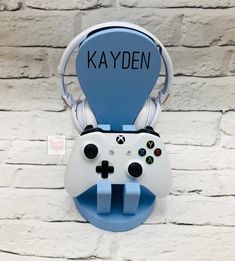 a video game controller mounted to a brick wall with the word kayden on it