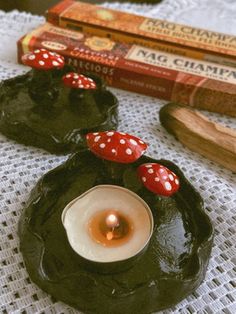 two candles sitting on top of a doily next to some books and other items