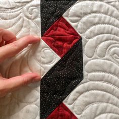 a person's hand on top of a quilt