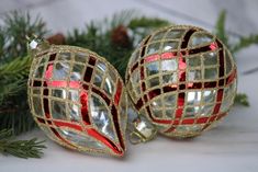 two christmas ornaments sitting on top of a table