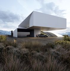 a car is parked in front of a white building with stairs on the roof and grass around it