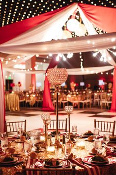 a table set up for an event with lights on the ceiling