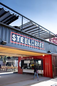 a man walking past a restaurant under a metal roof