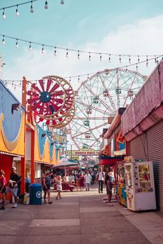 an amusement park filled with lots of rides and people walking through the fairgrounds